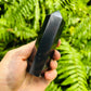 Near view of Shungite polished point, sourced from Republic of Karélia, Russia, showing glassy finish.