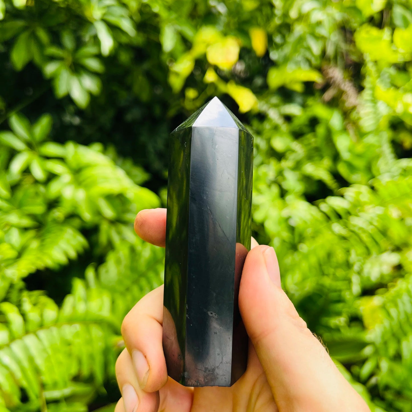 Sideways view of Shungite polished point, associated with Protection and Cleansing, hand-selected from Republic of Karélia, Russia.