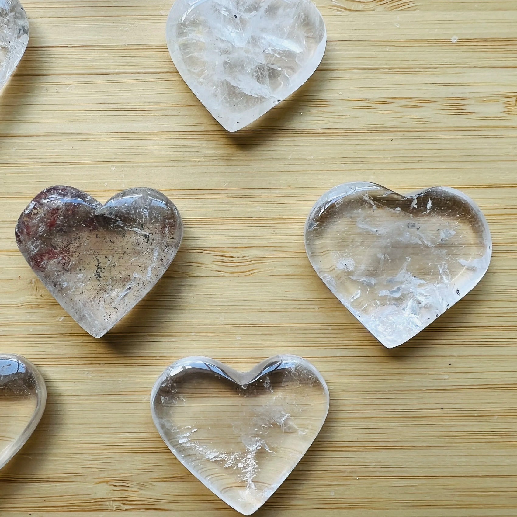 In-hand view of one Clear Quartz polished heart for scale, from Minas Gerais, Brazil.