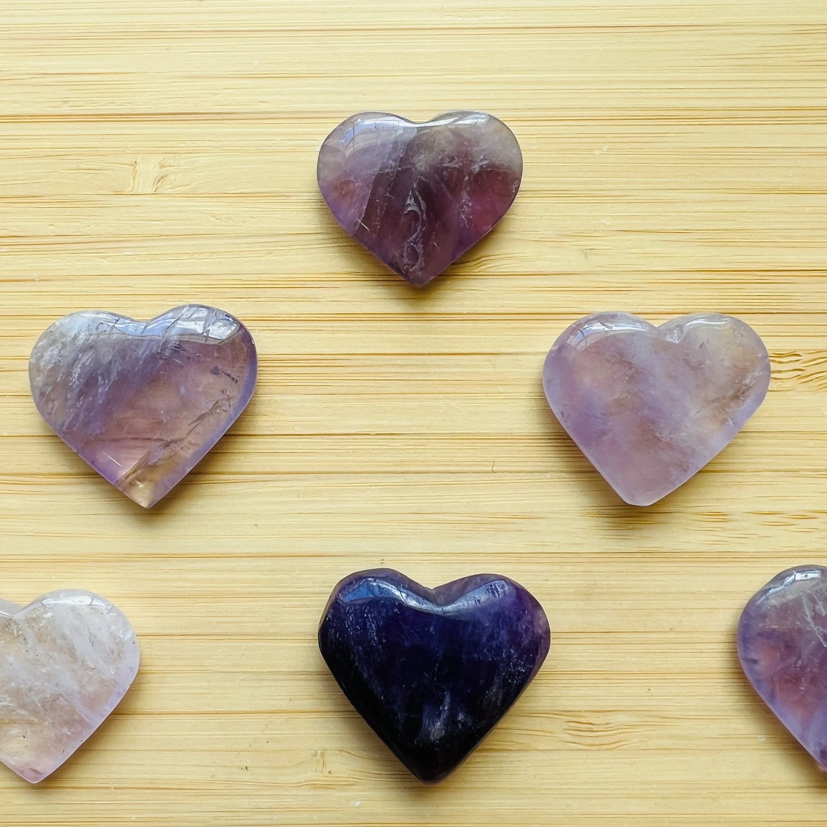 Palm-scale view of a single Amethyst polished heart Brazil-sourced, sourced from Rio Grande do Sul, Brazil.