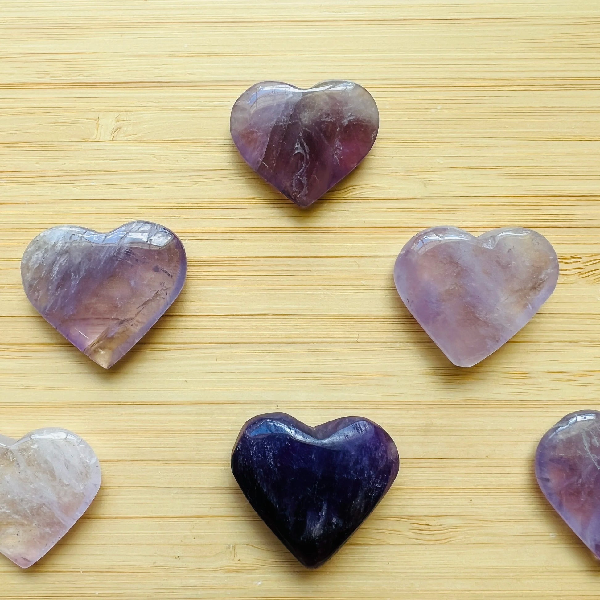 Palm-scale view of a single Amethyst polished heart Brazil-sourced, sourced from Rio Grande do Sul, Brazil.