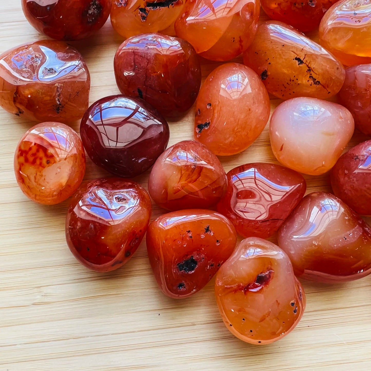 Close-up detail of Grade AA Carnelian tumbled stone showing natural orange, red tones and texture