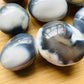 Color detail of Grade AA Orca Agate palm stone, often kept for Stress Relief and Emotional Healing, from Sofia, Madagascar.