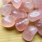 Close-up detail of Grade AAA Rose Quartz tumbled stone showing natural pink tones and texture