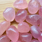 Side profile of Grade AAA Rose Quartz tumbled stone with natural form and inclusions