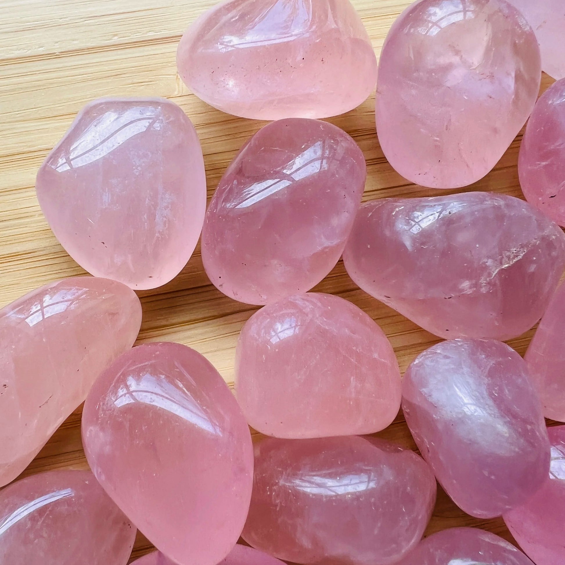 Side profile of Grade AAA Rose Quartz tumbled stone with natural form and inclusions