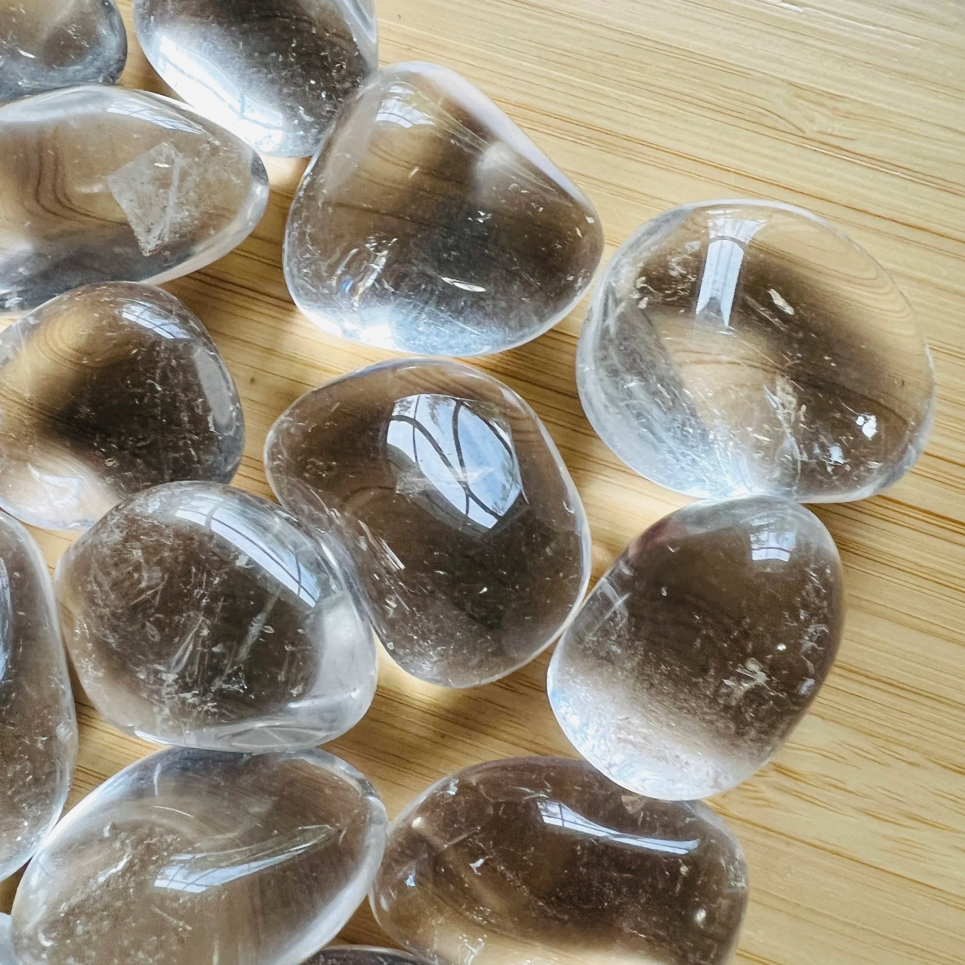 Palm-scale view of one Clear Quartz tumbled stone for scale, hand-selected from Minas Gerais, Brazil.