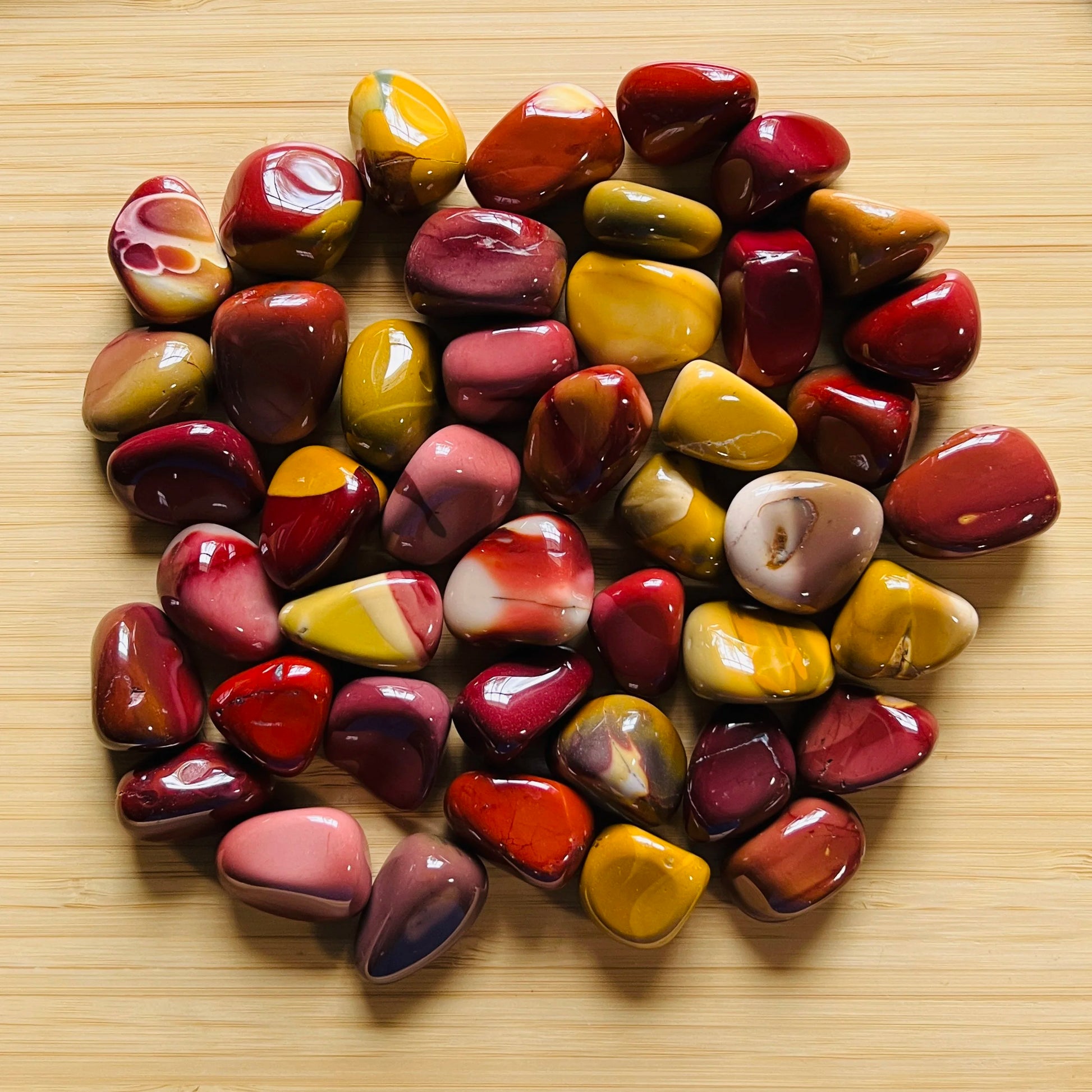 Grouping of Mookaite jasper tumbles, Grade AA, natural ochre and burgundy coloration