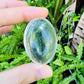 Back view of Grade AA Clear Quartz palm stone showing natural surface
