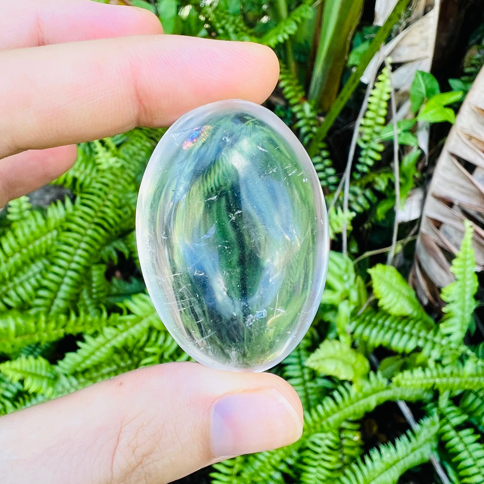 Back view of Grade AA Clear Quartz palm stone showing natural surface
