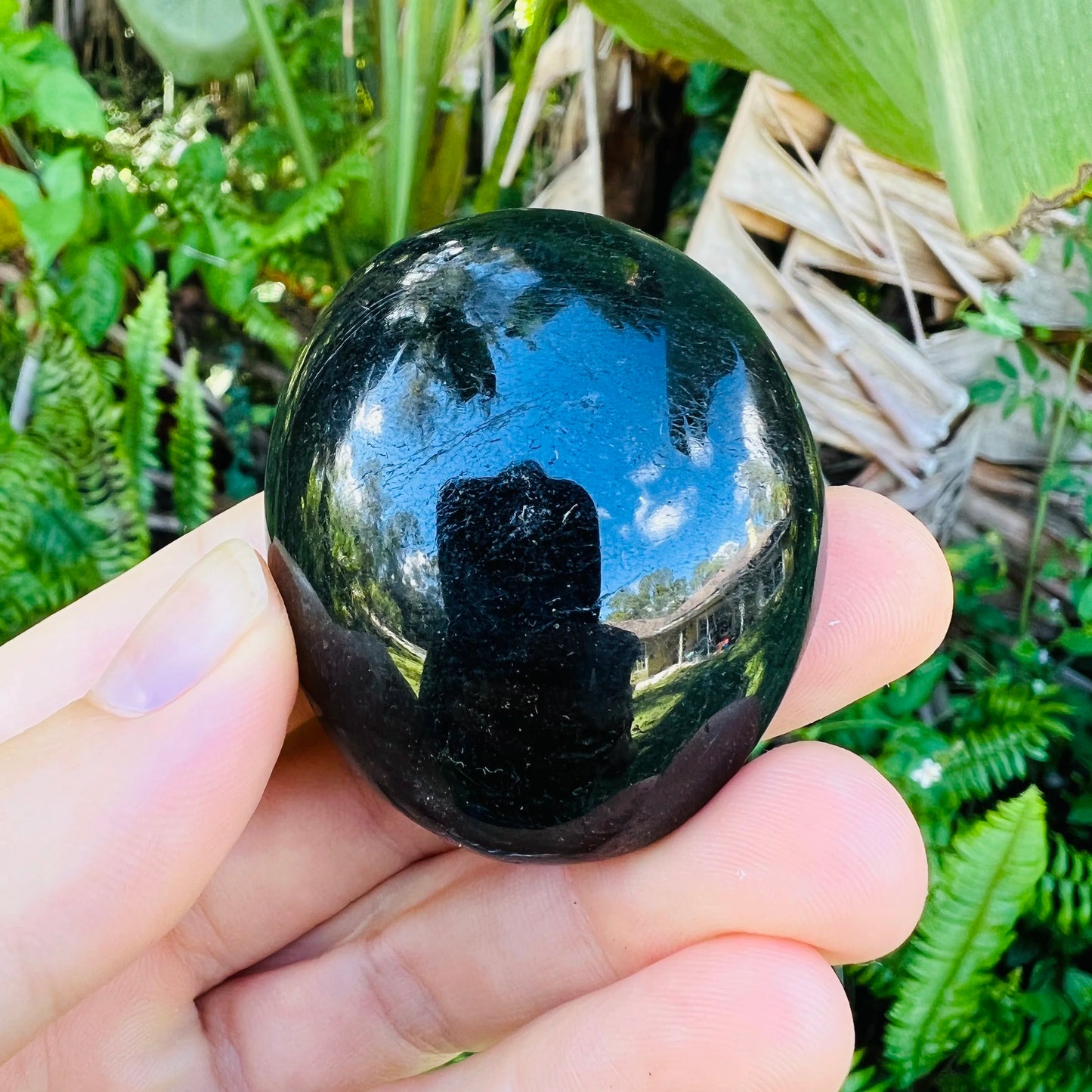 Held in hand, a Black Tourmaline palm stone kept near for Protection and Grounding.