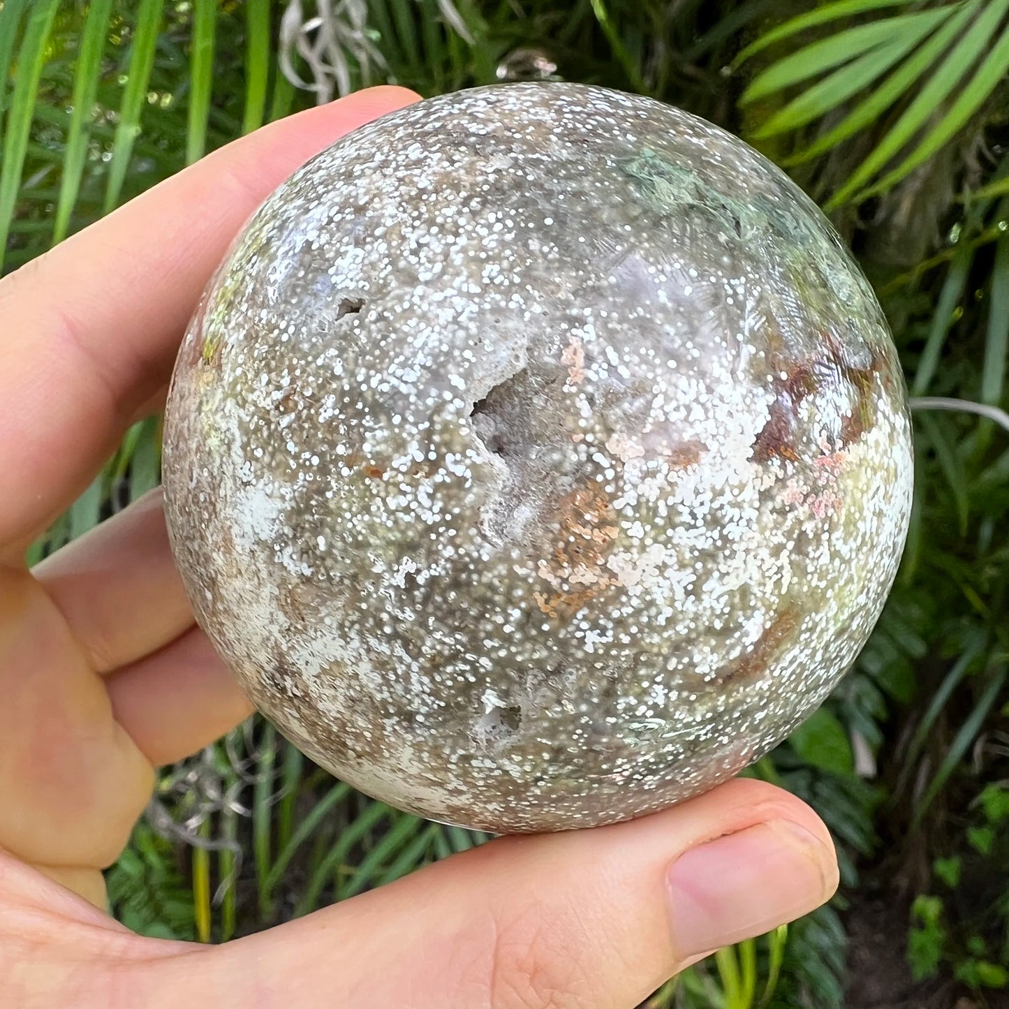 Palm-scale view of a Ocean Jasper polished sphere to support Emotional Healing.