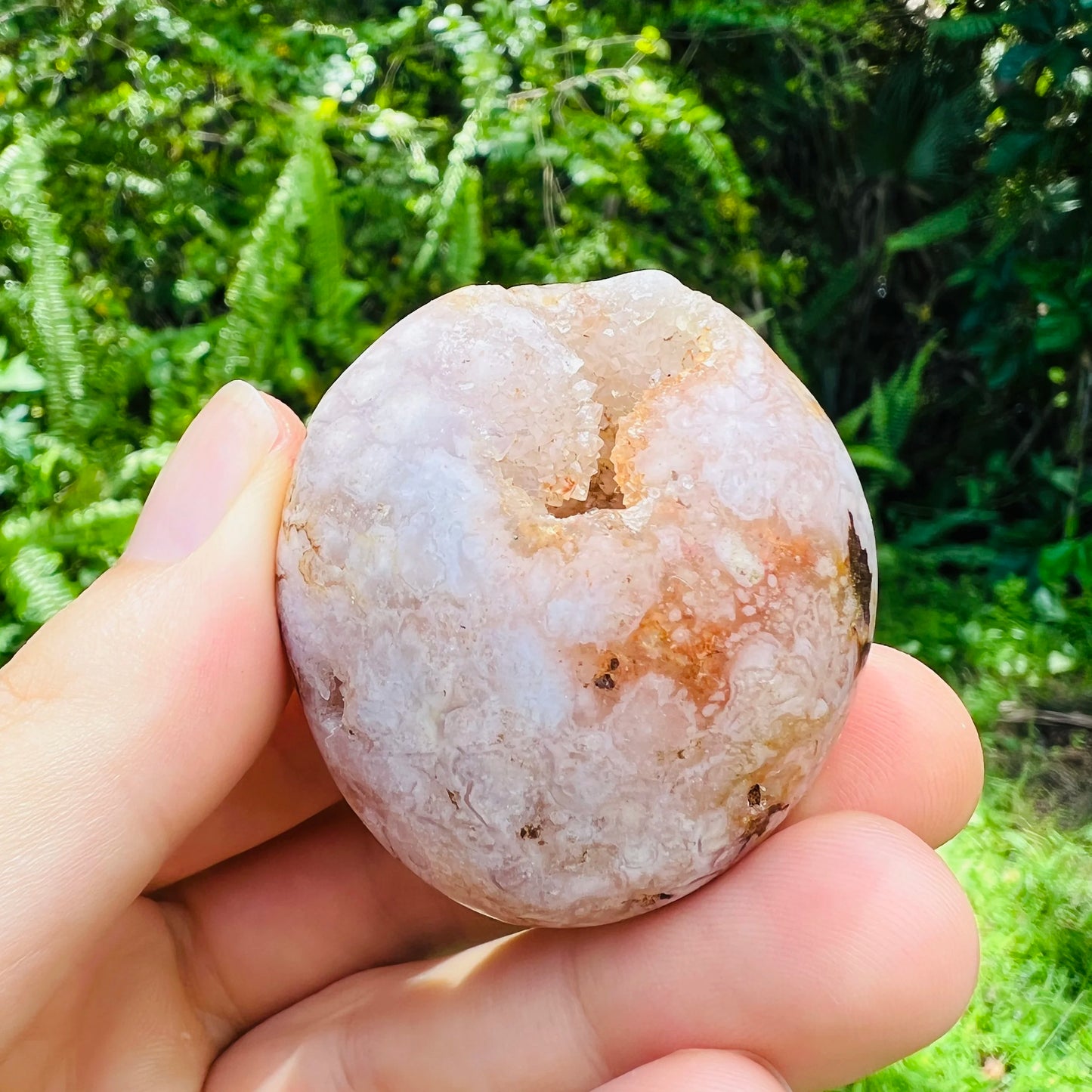 Hand-scale view of Flower Agate palm stone, from Boeny, Madagascar, shown at hand scale.