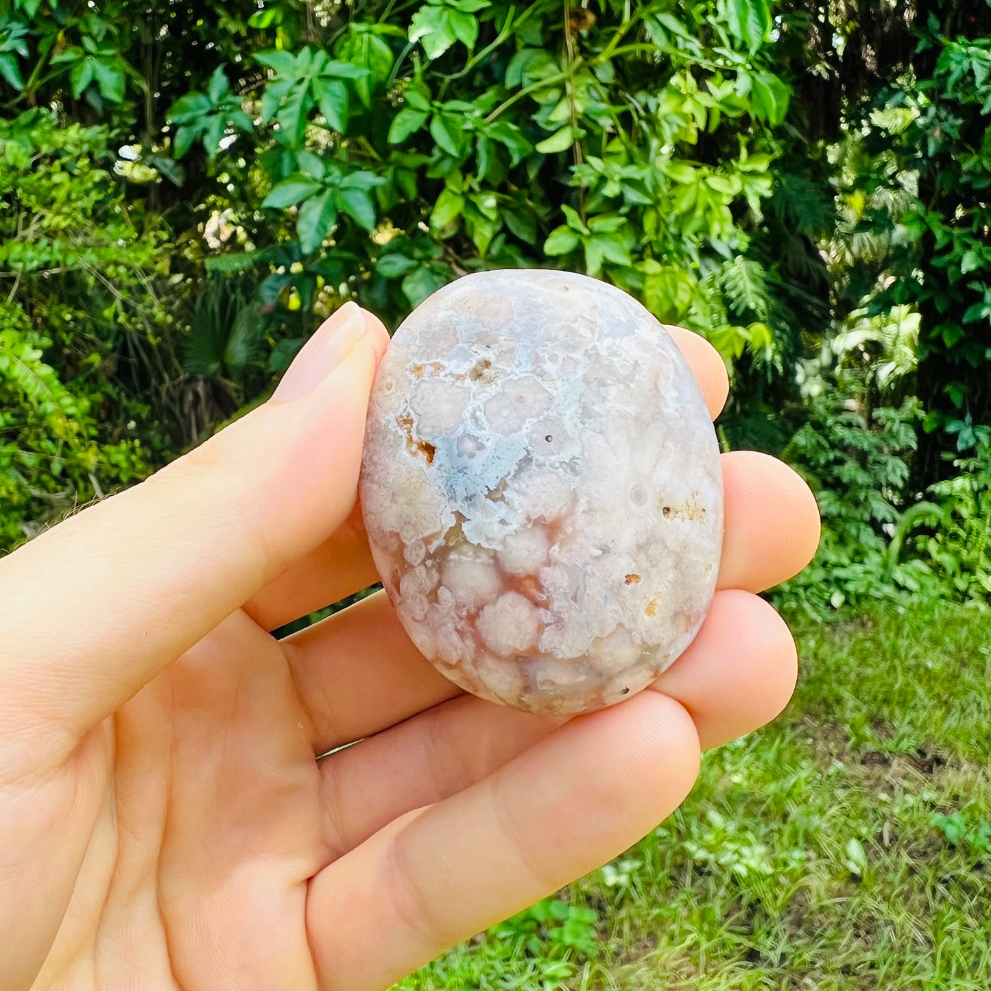 Hand-scale shot of a Flower Agate palm stone, sourced from Madagascar.