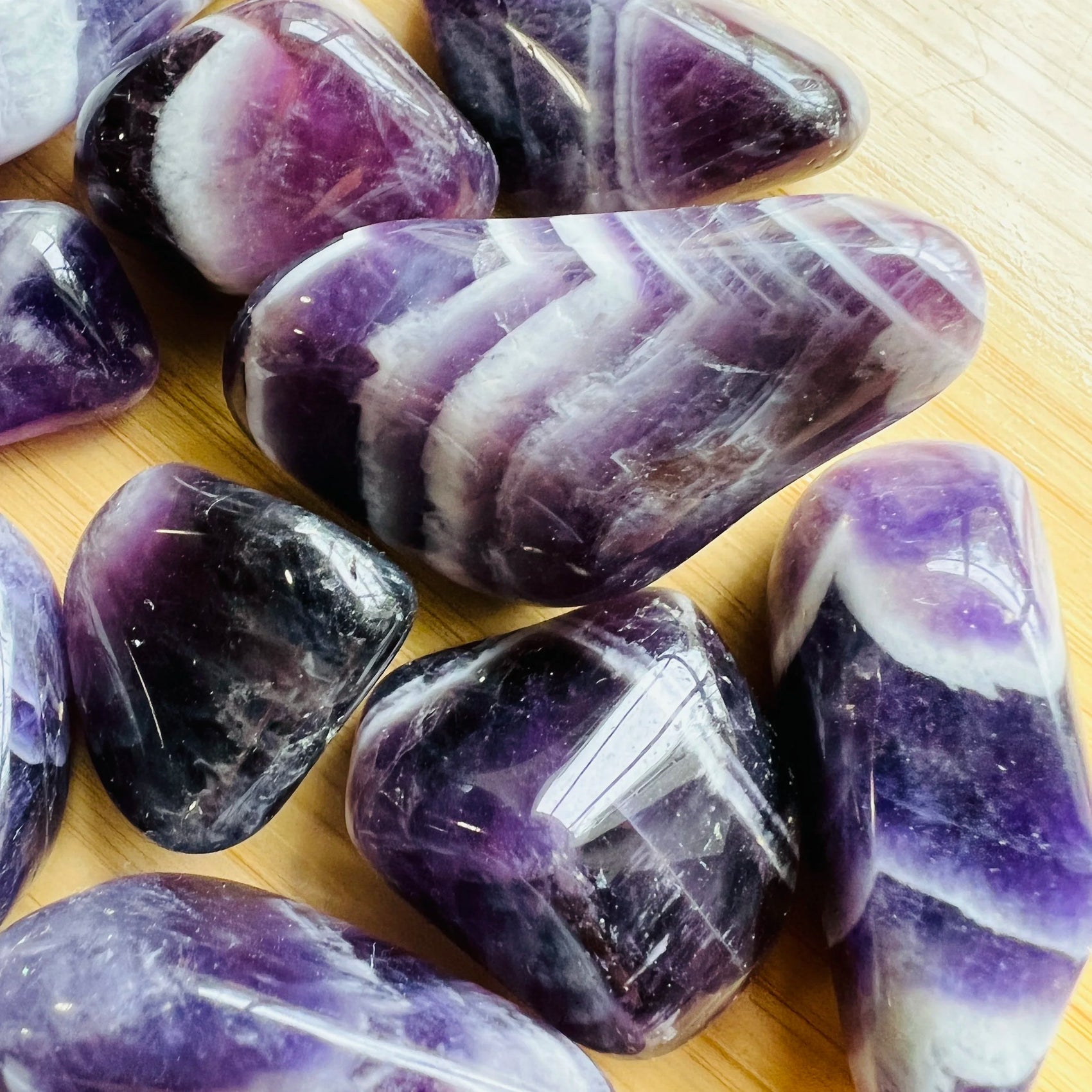 Top view of Chevron Amethyst tumbled stone, showing characteristic color.