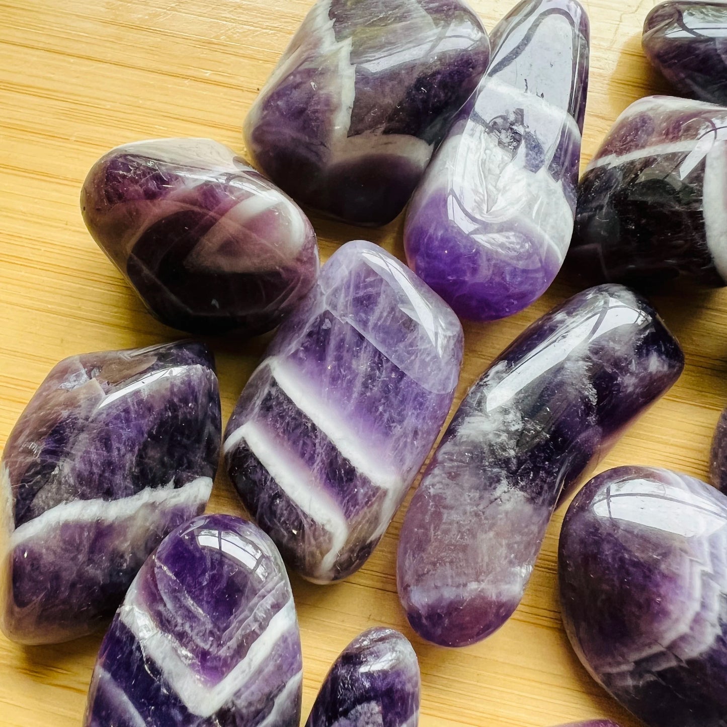 Lateral view of Grade AA Chevron Amethyst tumbled stone, showing characteristic patterning.