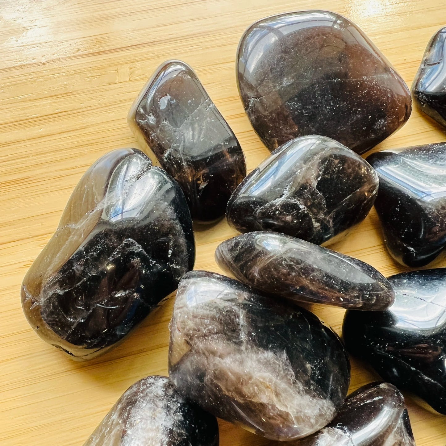 Overhead view of Grade AA Smoky Quartz tumbled stone, hand-selected from Vakinankaratra, Madagascar.