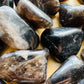 Scale reference of one Smoky Quartz tumbled stone for scale, Madagascar-sourced, sourced from Madagascar.