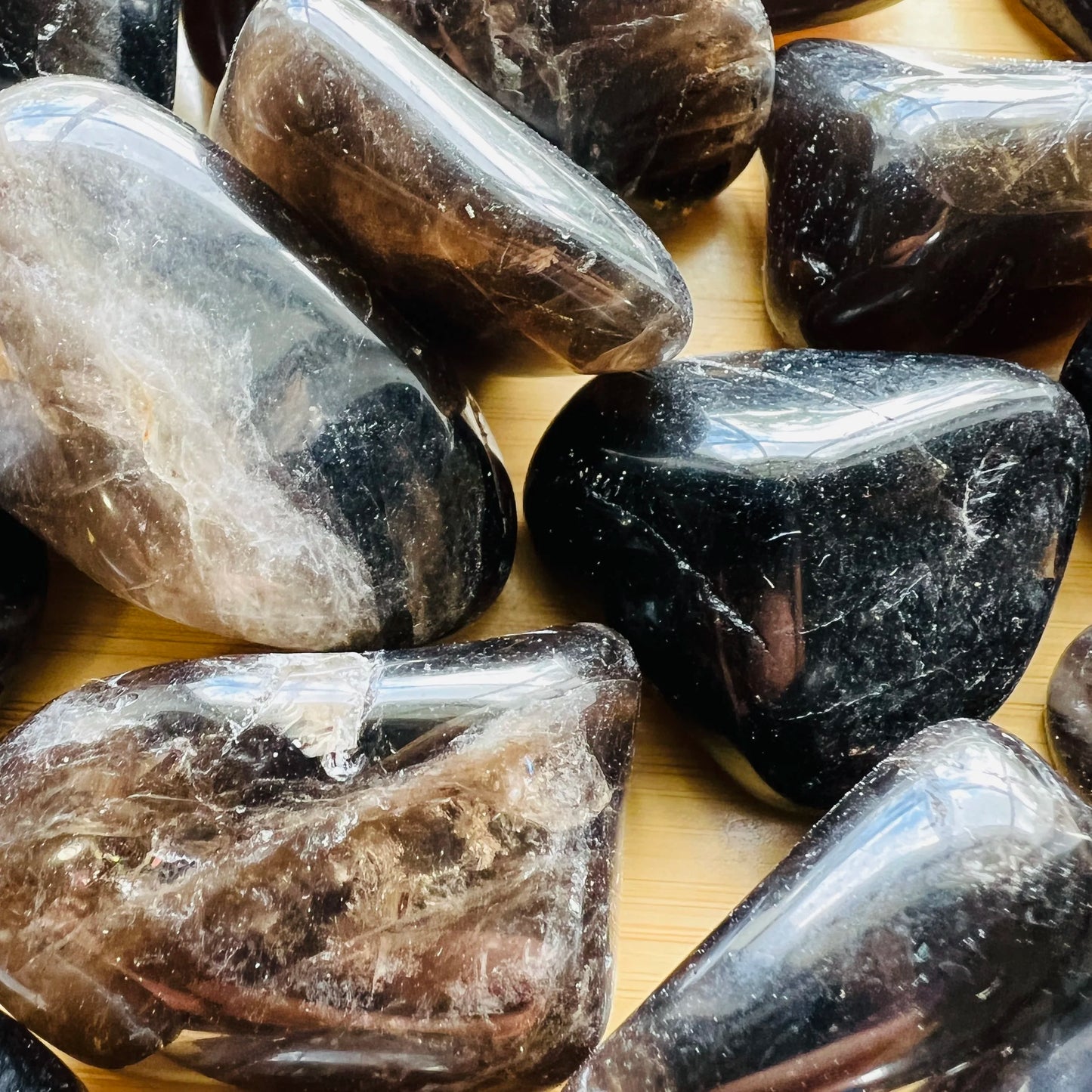 Scale reference of one Smoky Quartz tumbled stone for scale, Madagascar-sourced, sourced from Madagascar.