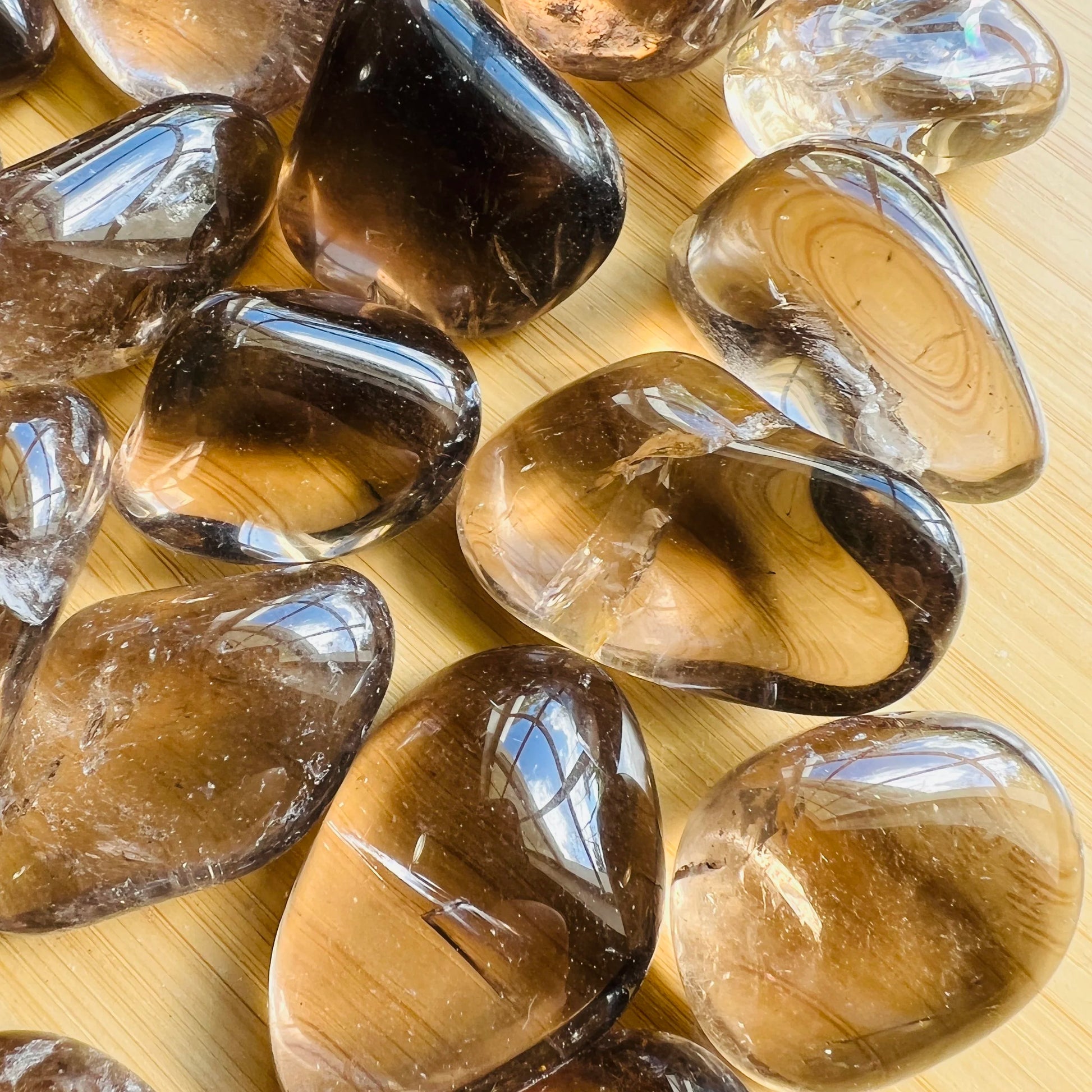 Underside view of Grade AAA Smoky Quartz tumbled stone, showing glassy finish, from Brazil.