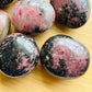 Full profile of Grade AA Rhodonite palm stone ready to ship from Beyond Bohemian