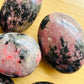 Full profile of Grade AA Rhodonite palm stone ready to ship from Beyond Bohemian