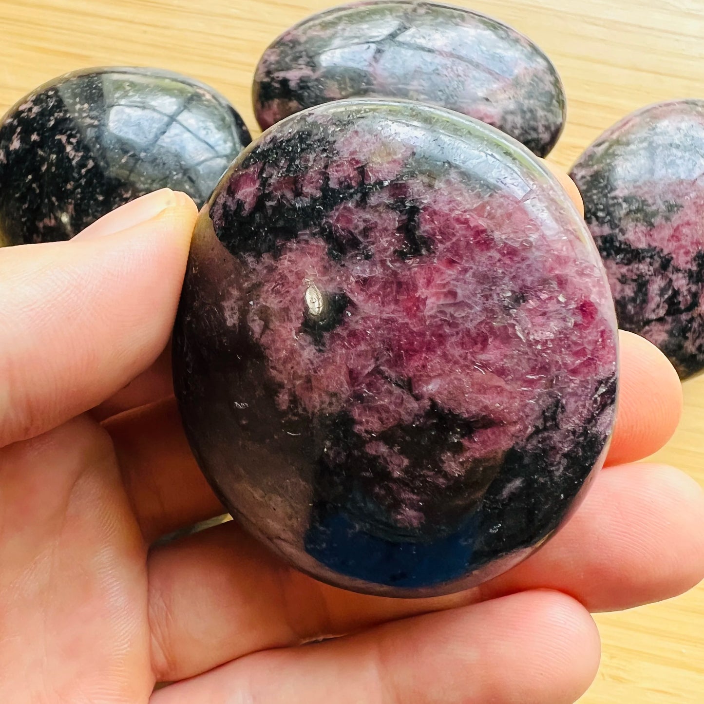 Top-down shot of Rhodonite palm stone, showing translucent edges.