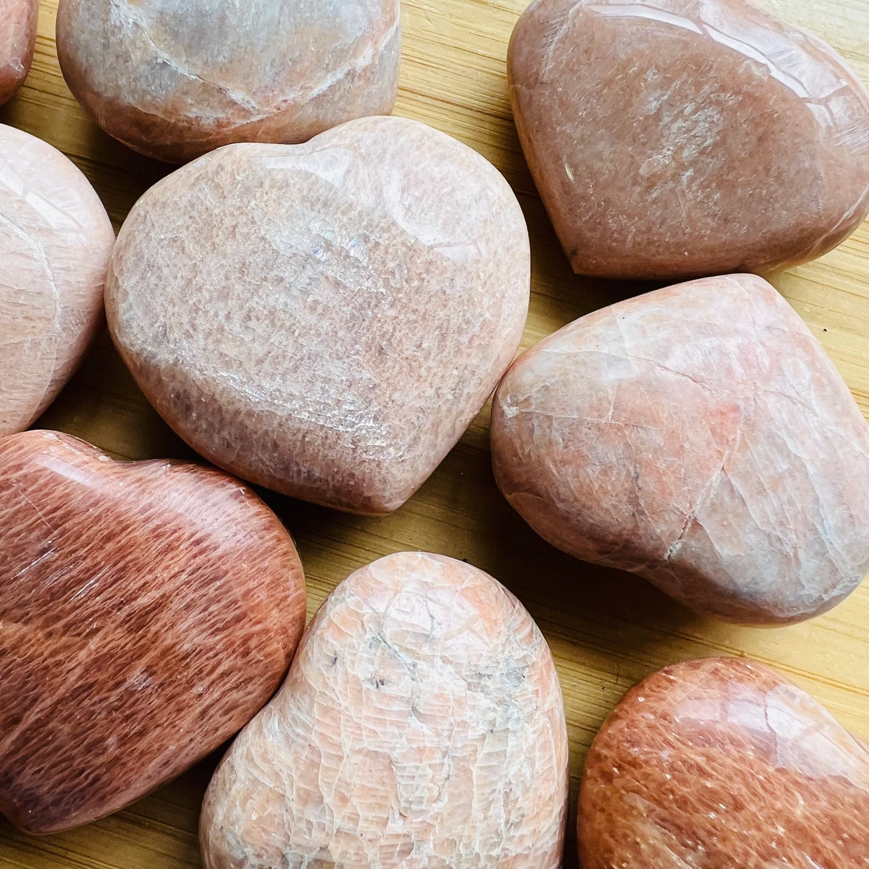 Natural light context of Peach Moonstone stone, from Alaotra-Mangoro, Madagascar, shown alongside the hand for scale.