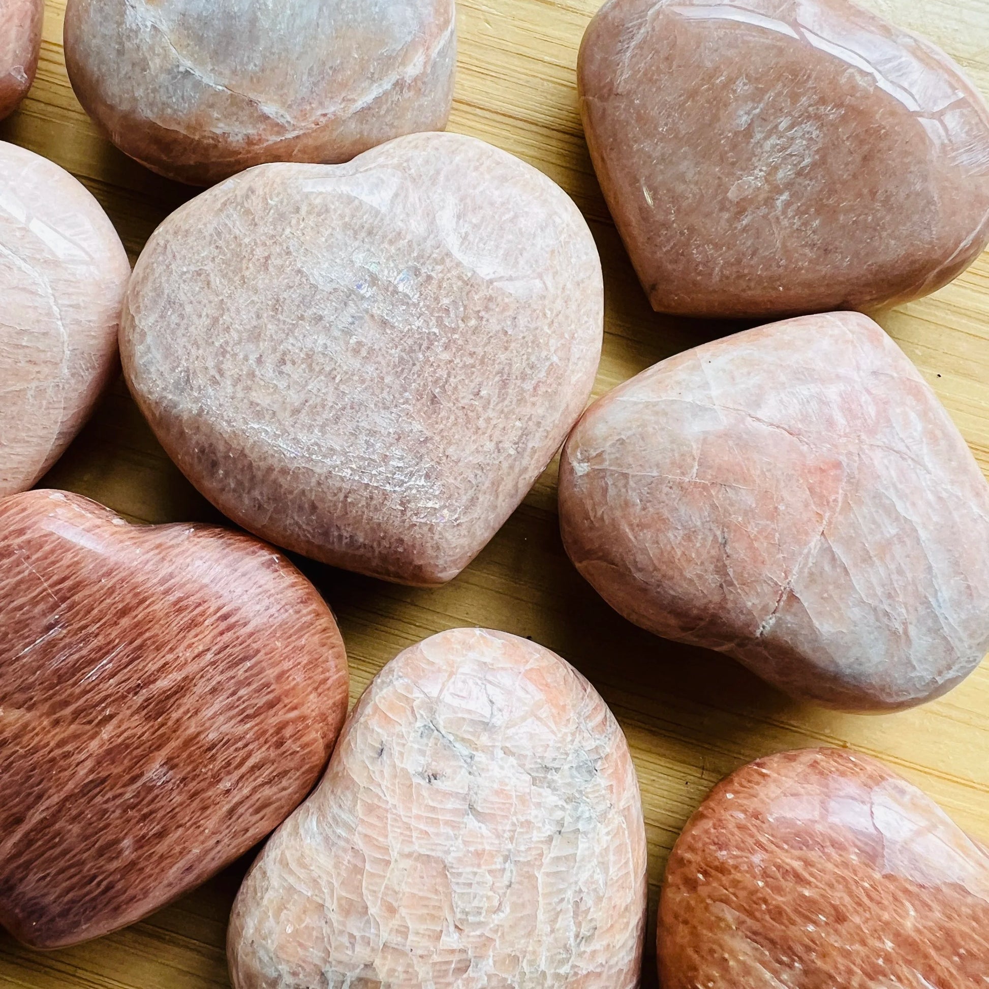Natural light context of Peach Moonstone stone, from Alaotra-Mangoro, Madagascar, shown alongside the hand for scale.