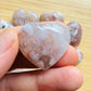 Hand-held view of a Flower Agate polished heart, from Madagascar.