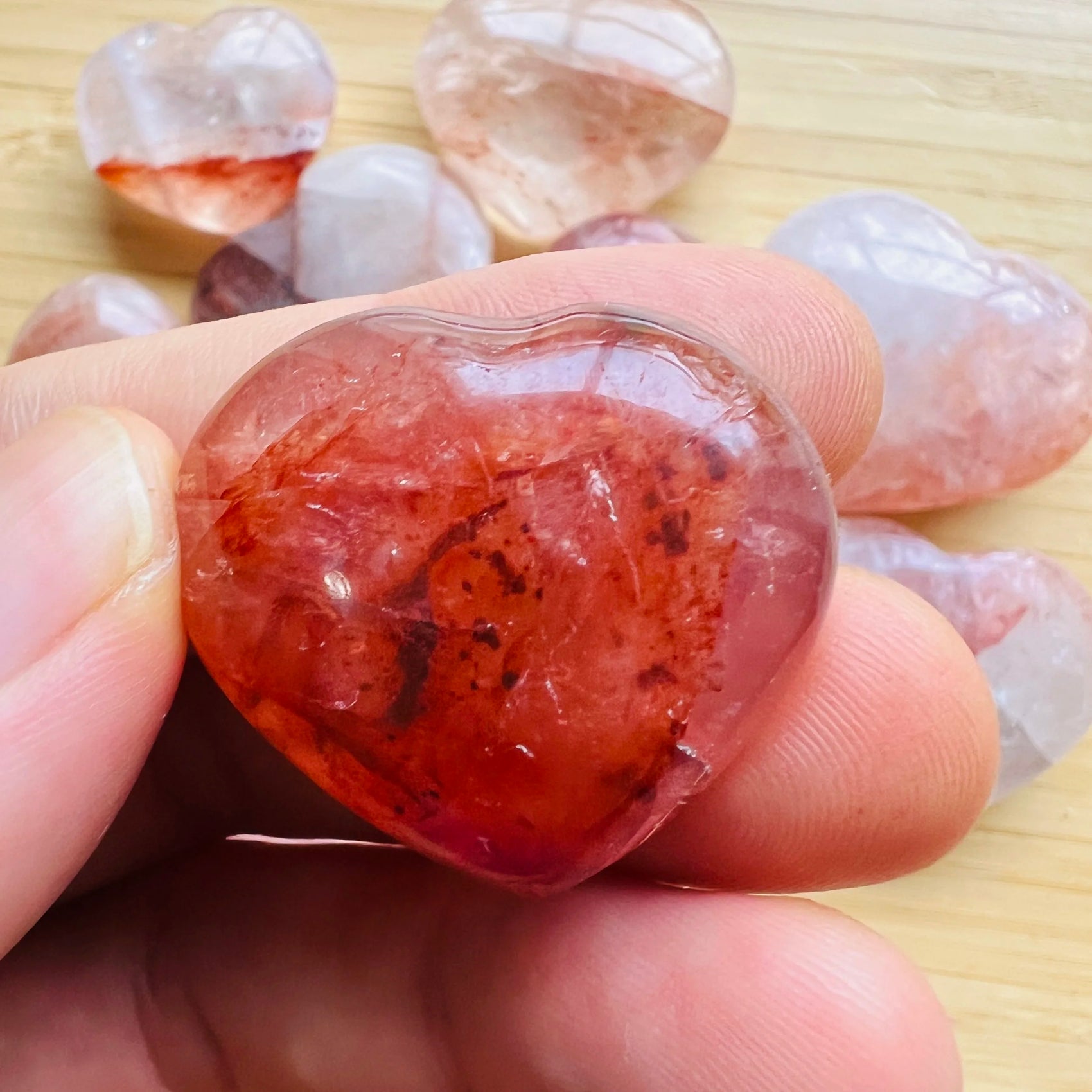 Held in hand is a Fire Quartz stone, with character of the piece on display.