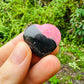 Edge-on view of Rhodonite polished heart, showing translucent edges, hand-selected from Atsimo-Andrefana, Madagascar.