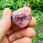 Side profile of Fire Quartz polished heart, sourced from Madagascar, showing color depth.