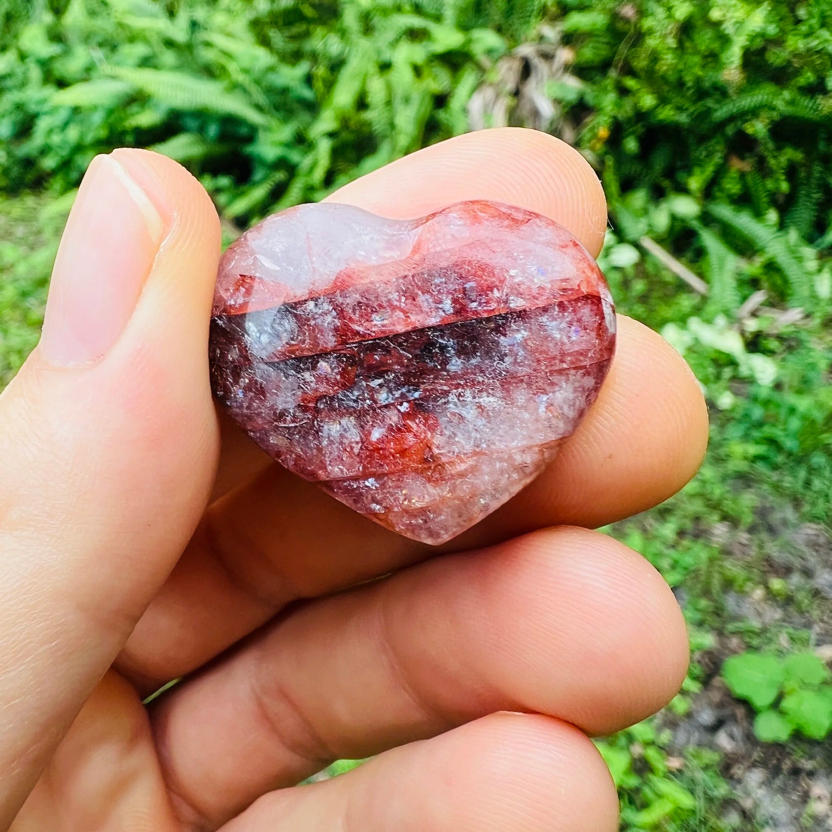 Side profile of Fire Quartz polished heart, sourced from Madagascar, showing color depth.