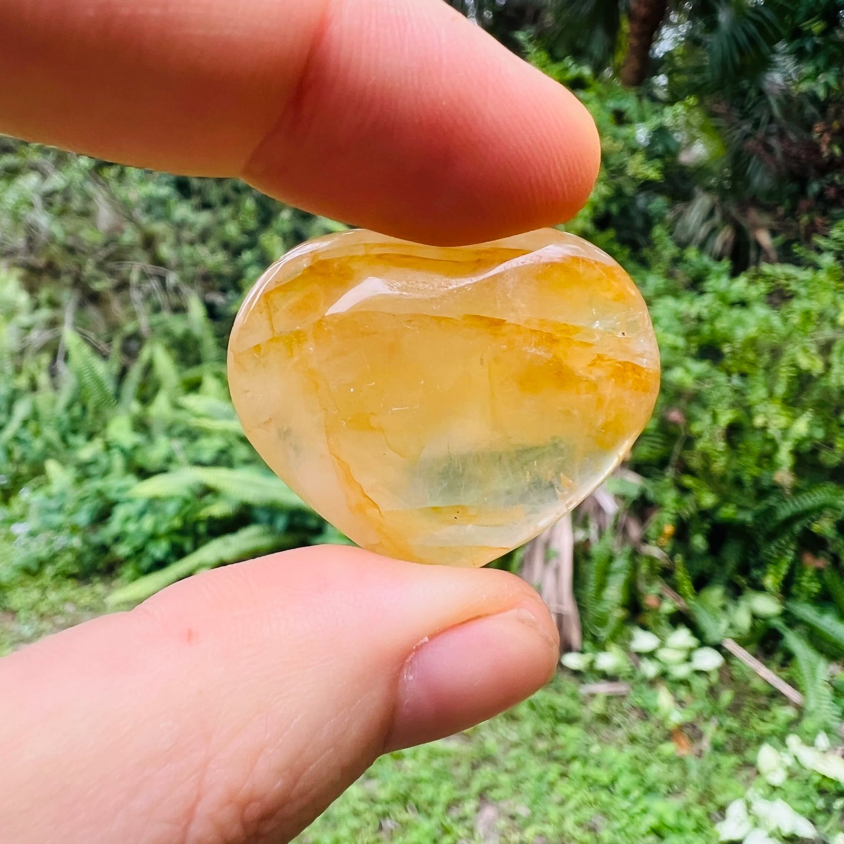 Edge-on view of Grade AA Golden Healer polished heart, sourced from Alaotra-Mangoro, Madagascar, showing natural texture.