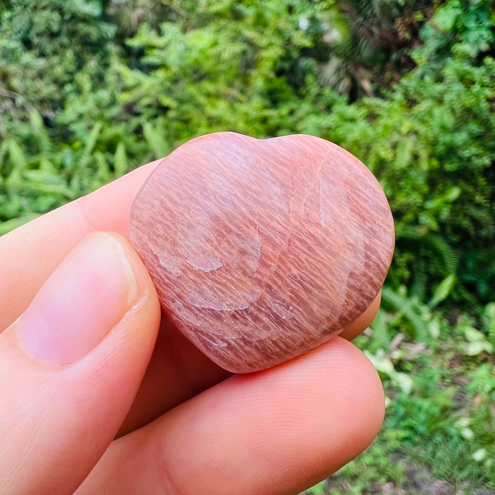 Sideways view of Peach Moonstone polished heart, showing characteristic patterning, sourced from Alaotra-Mangoro, Madagascar.