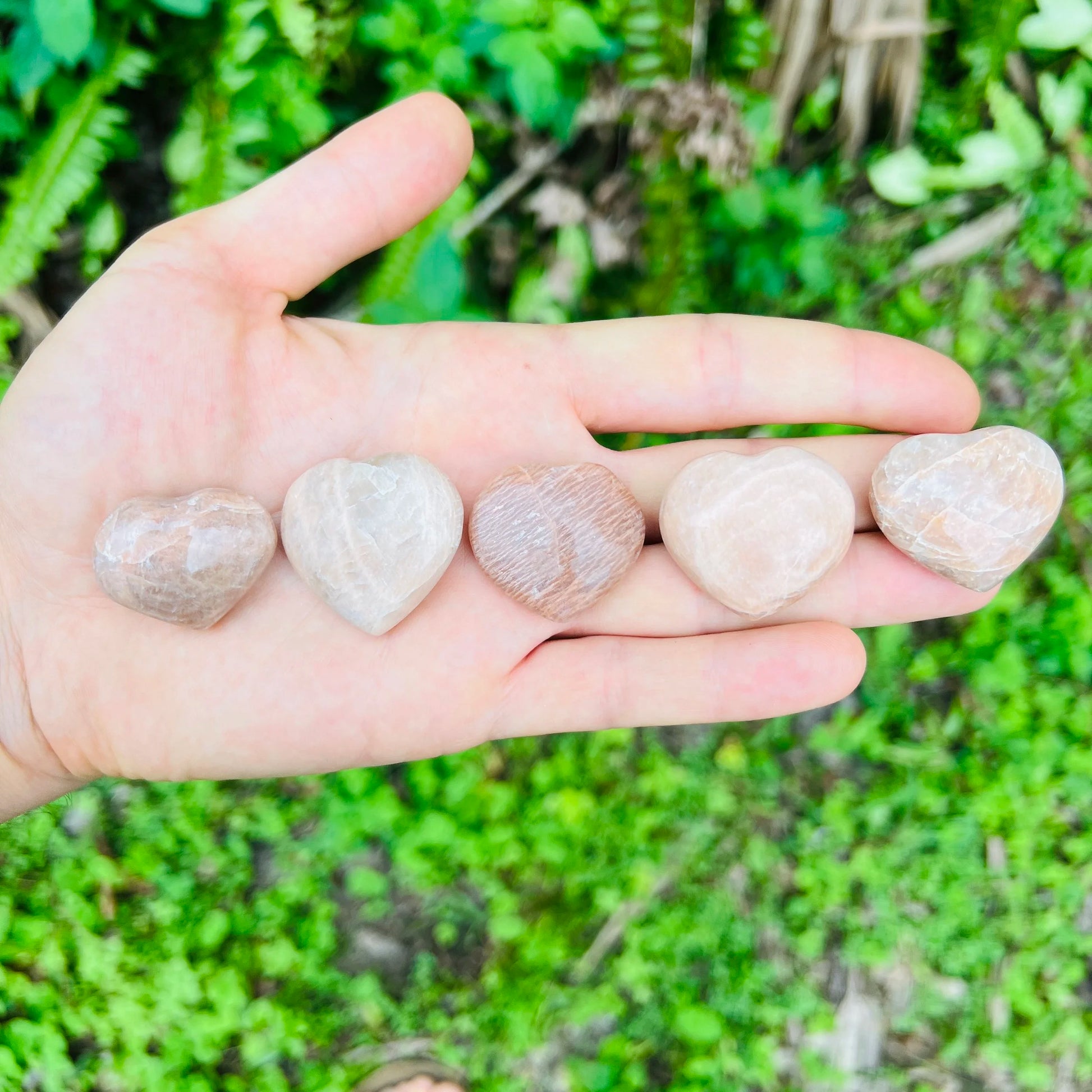 Texture-level view of Grade AA Peach Moonstone polished heart, from Madagascar, showing translucent edges.