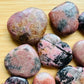 Back view of Rhodonite polished heart, showing natural sheen.