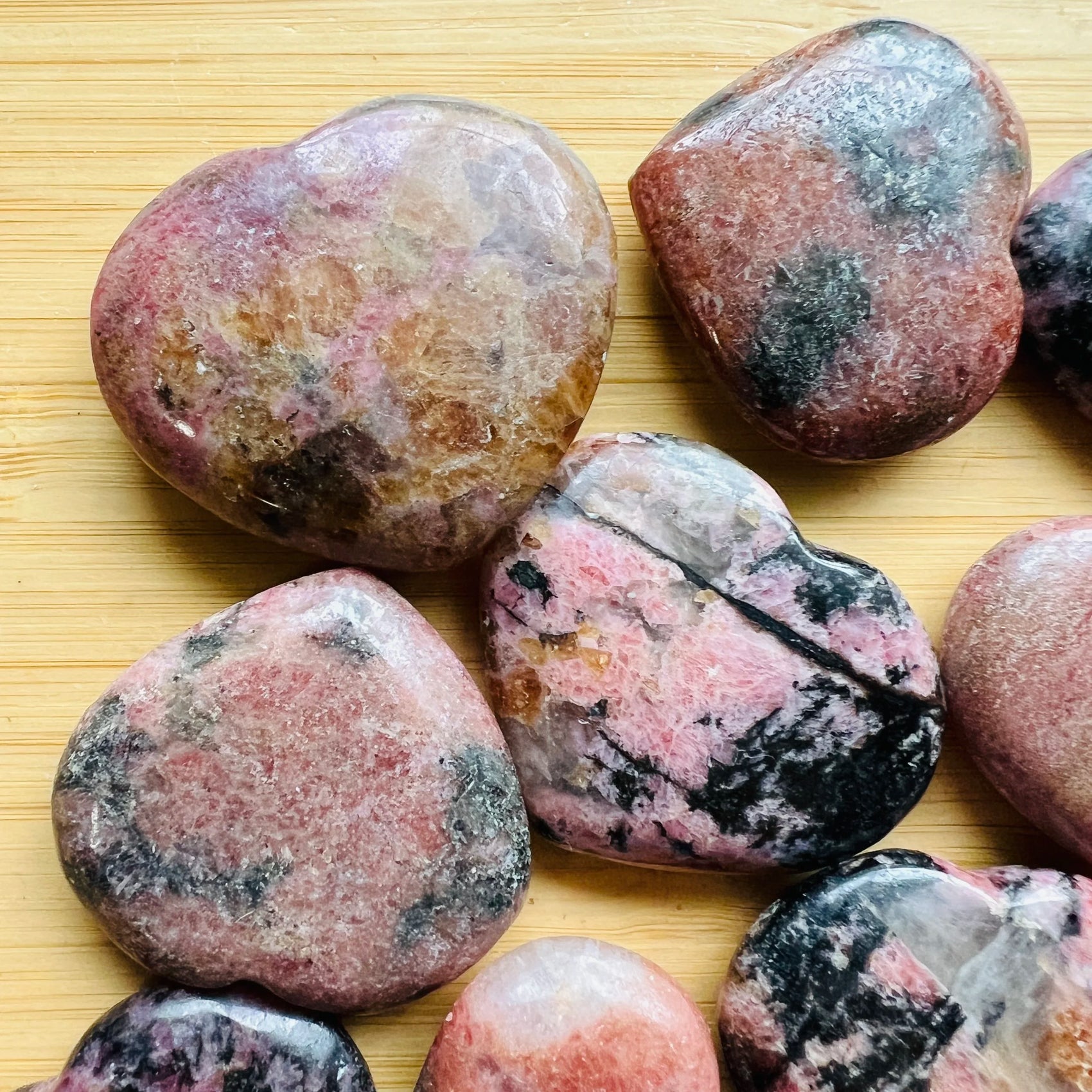 Back view of Rhodonite polished heart, showing natural sheen.