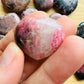 Composed shot of Rhodonite stone, from Atsimo-Andrefana, Madagascar, often kept for Self Love, with depth visible across the surface.