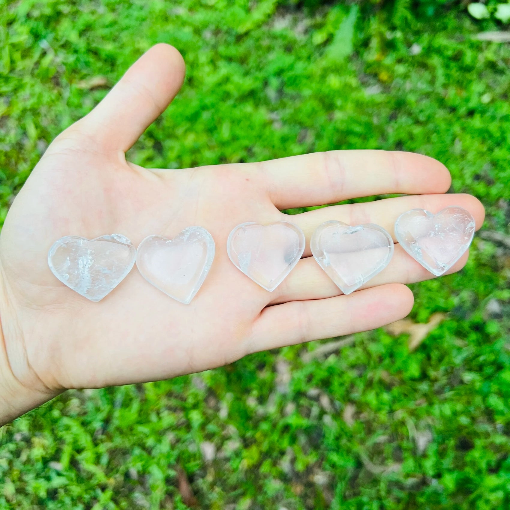 Near view of Clear Quartz polished heart, showing natural inclusions, kept close for Cleansing.