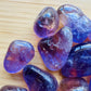 Top view of Grade AAA Ametrine tumbled stone, showing glassy finish, hand-selected from Ángel Sandoval Province, Bolivia.