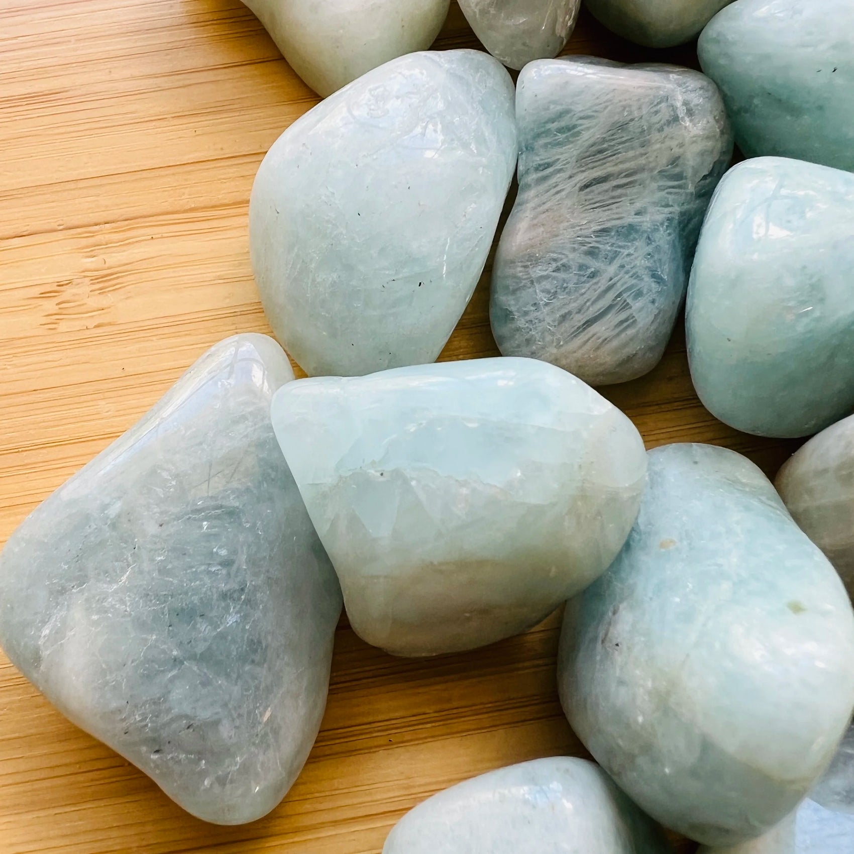 Detail of Aquamarine tumbled stone, showing natural sheen, linked to Stress Relief.