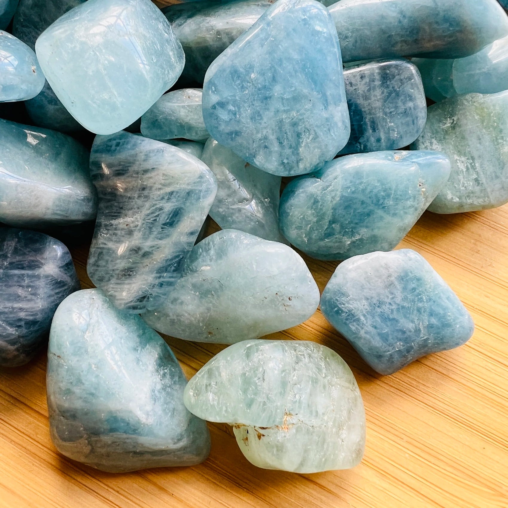 Side perspective of Aquamarine tumbled stone, showing characteristic color, sourced from Brazil.