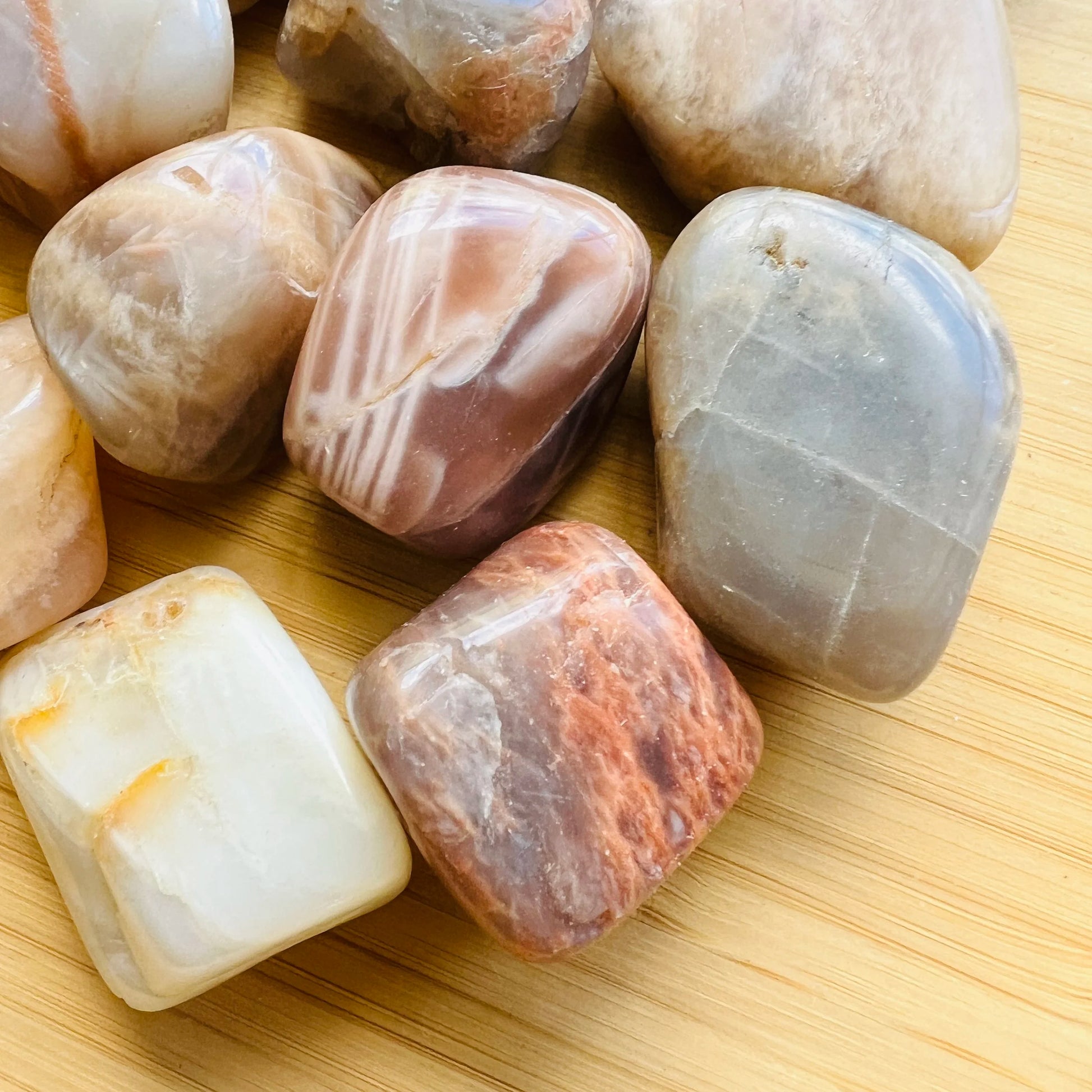 Detail shot showing brown Earth Moonstone tumbled stone, sourced from Brazil.