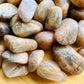 Macro view of Earth Moonstone tumbled stone, Brazil-sourced, showing characteristic finish.