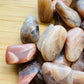 Underside view of Grade AA Earth Moonstone tumbled stone, from Brazil, showing subtle veining.