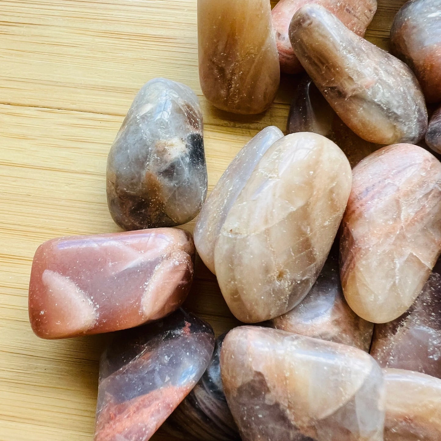 Underside view of Grade AA Earth Moonstone tumbled stone, from Brazil, showing subtle veining.