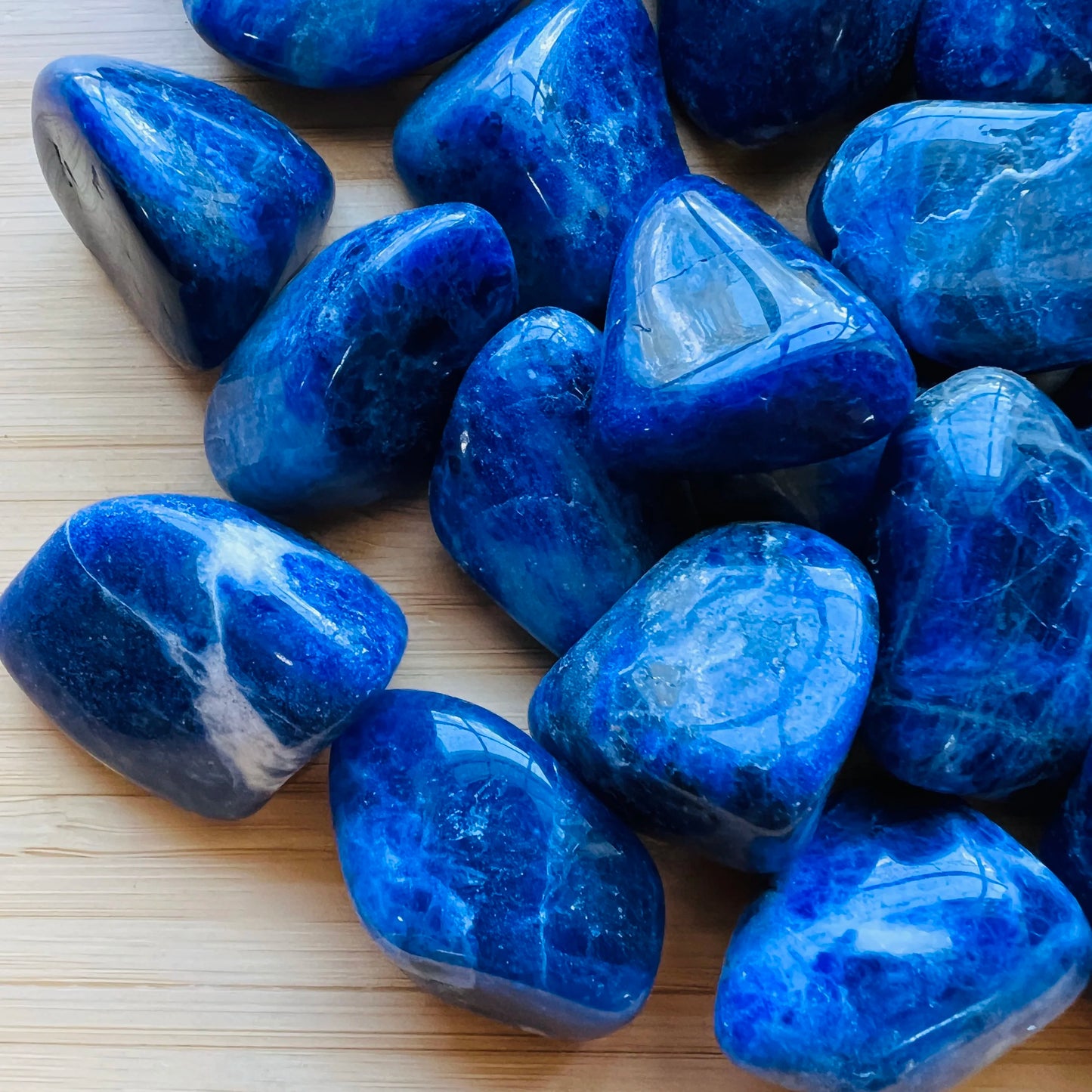 Side perspective of Grade A Sodalite tumbled stone, showing natural variation.