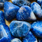 Reverse side of Sodalite tumbled stone, from Brazil, showing translucent edges.